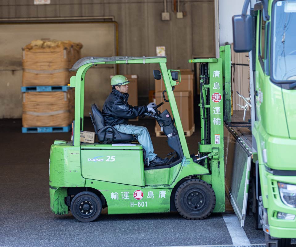 フォークリフトで荷物を運ぶ作業員