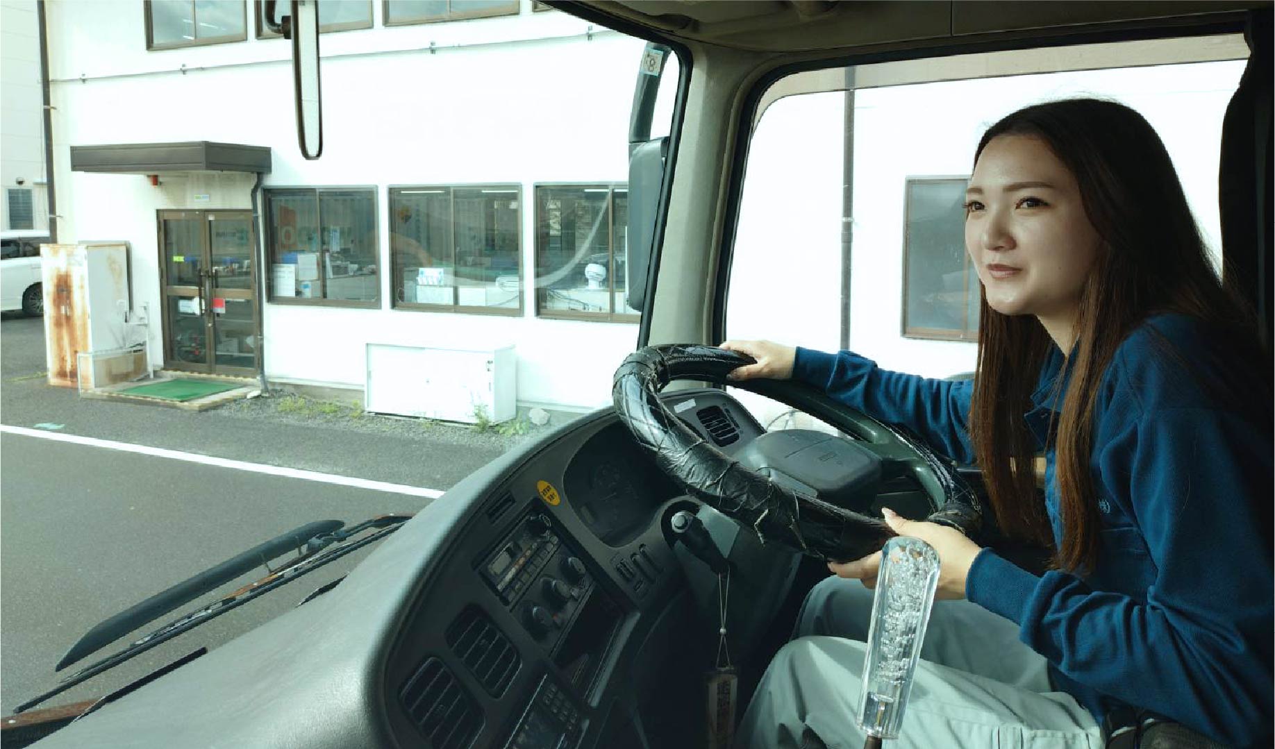 トラックの運転席に座る輸送部門の社員